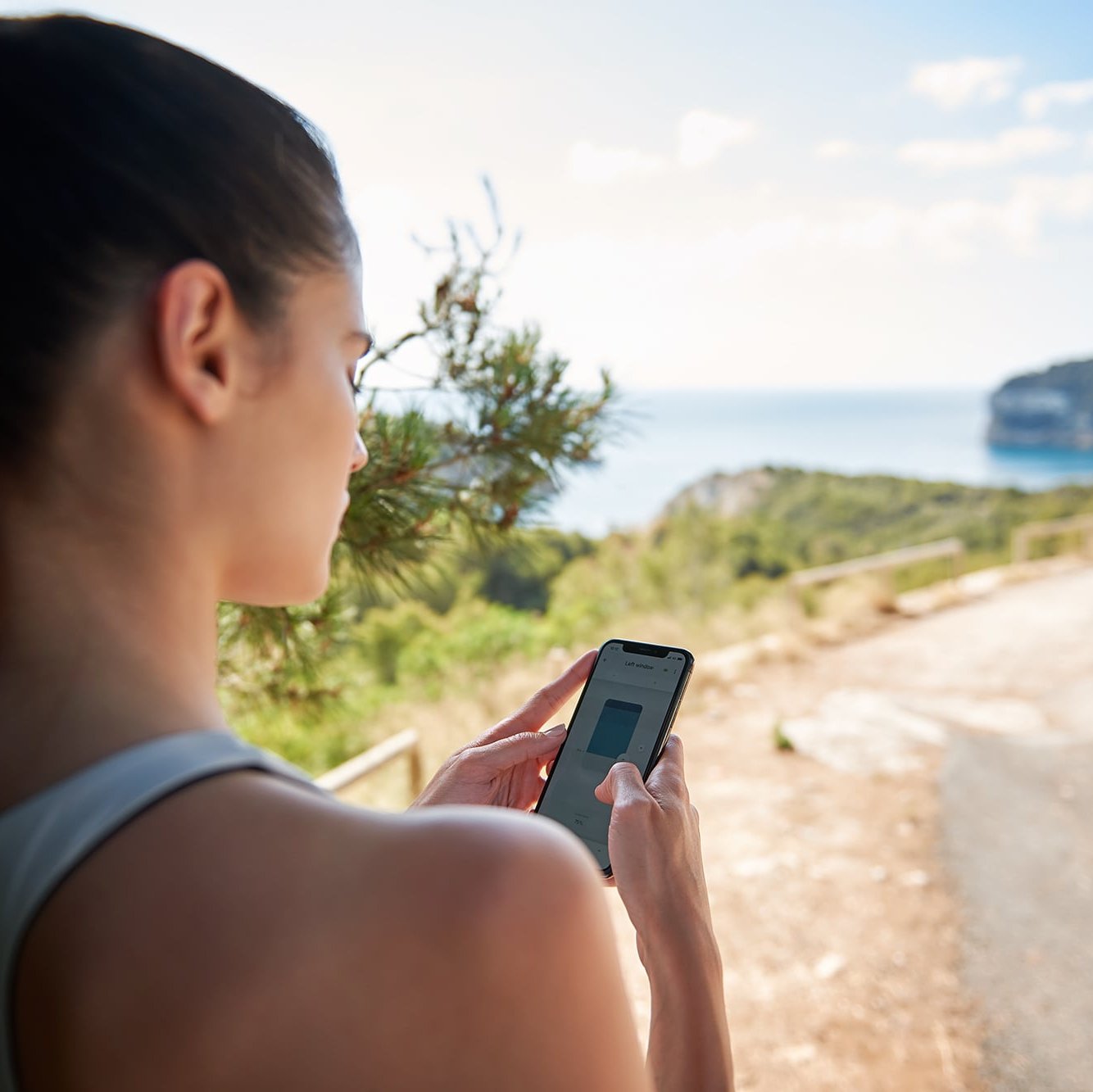 [Translate to English:] Frau steuert per Smartphone App ihren KADECO Sonnenschutz
