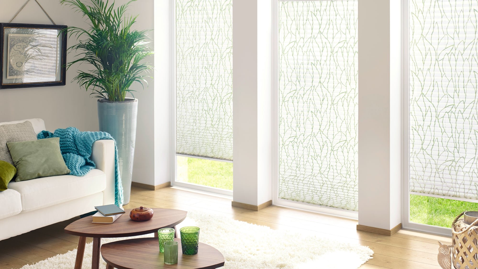 Grün-weißes Plissee im gemütlichen Wohnzimmer als eleganter Sichtschutz von KADECO.